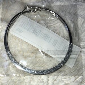 Silver hoop earrings with silver glitter and bottom of hoops.